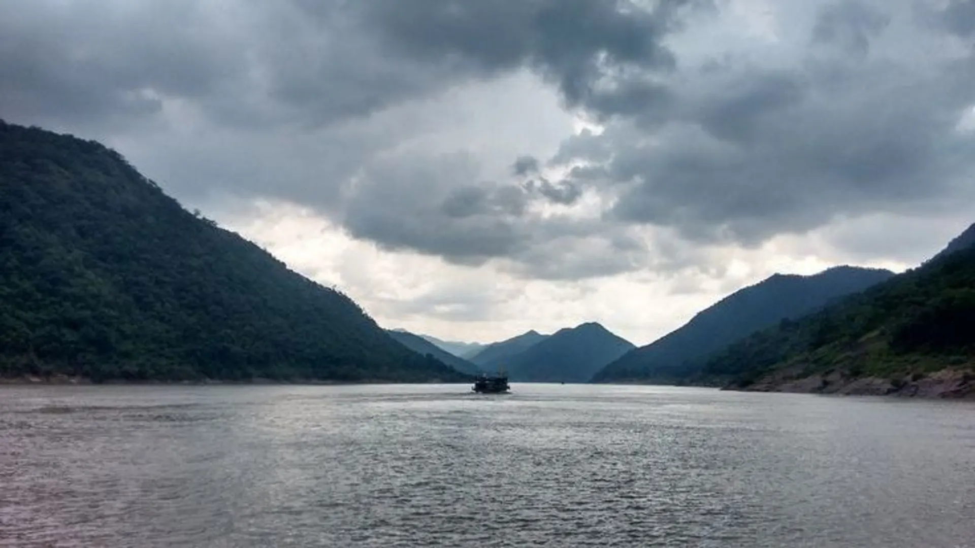 Tourist boat on the Godavari in the Papikondalu gorge under monsoon clouds